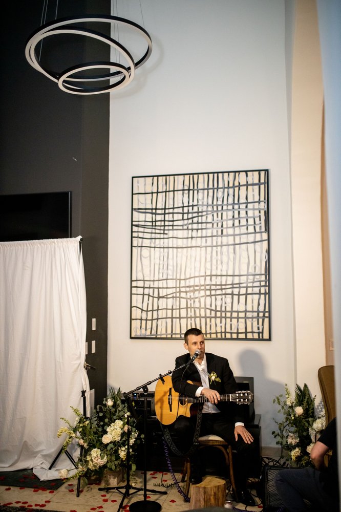 Coyah Gamble performing solo in a formal black suit at an upscale venue