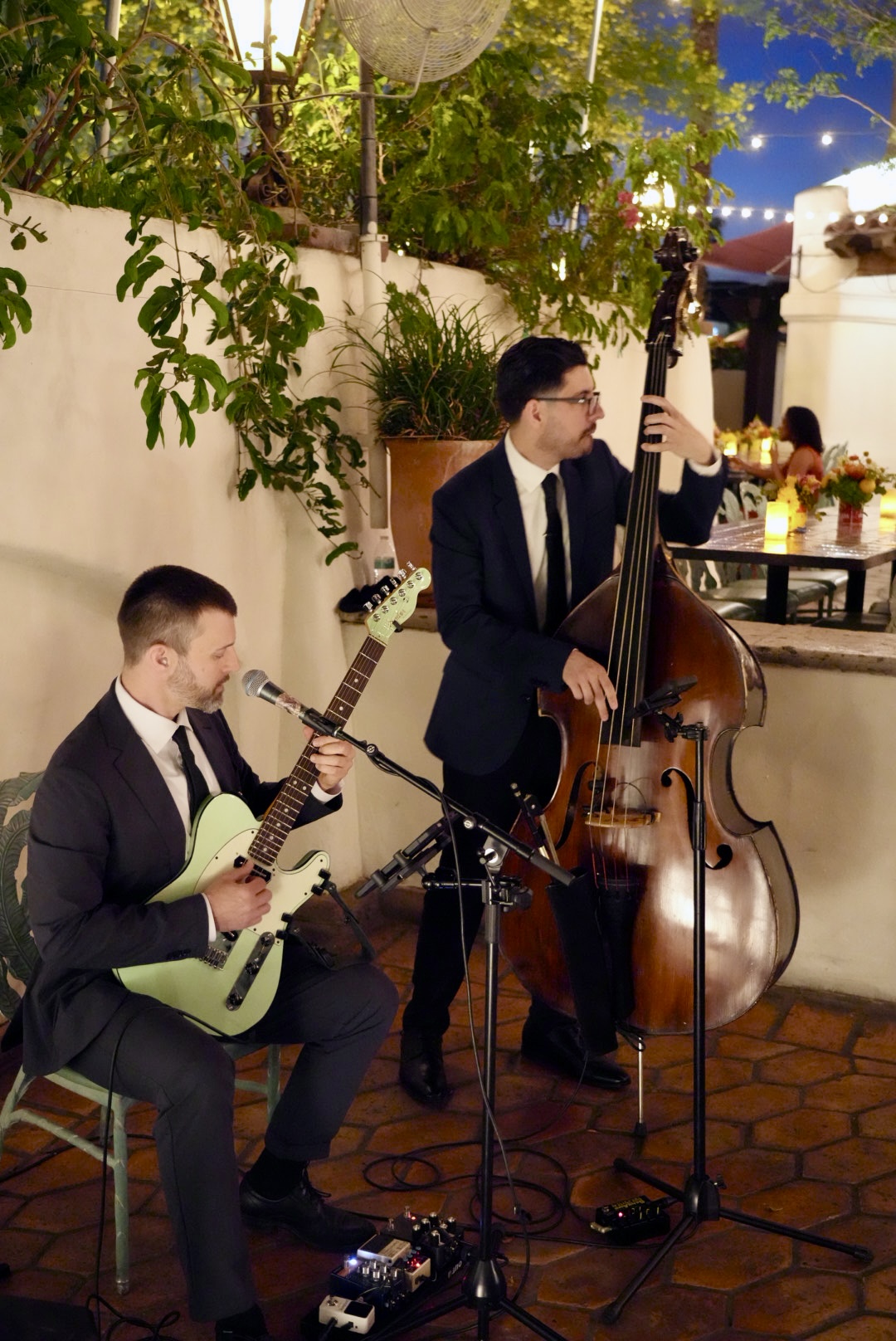 Coyah Gamble performing as a duo with an upright bassist at an evening courtyard event